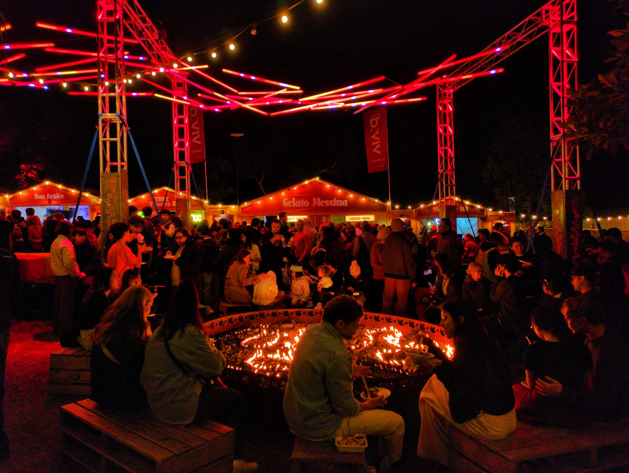 A large crowd fills a Vivid Sydney precinct in 2026.